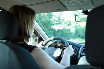 young woman attentively and carefully driving the car