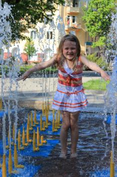 little sympathetic girl playing in fountains