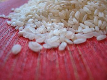 Handful of rice scattered on a red background