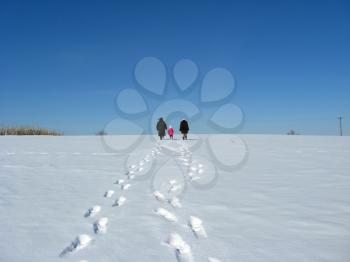 Outgoing people and traces on a snow not a background of the blue sky
