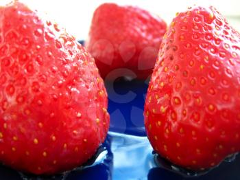 The image of berries of strawberries on blue saucer