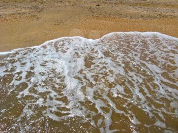 image of marine waves on the background of sand