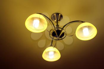 Beautiful chandelier with three bright plafonds under the ceiling