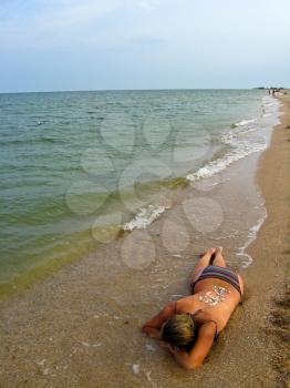 the image of the girl laying on seacoast