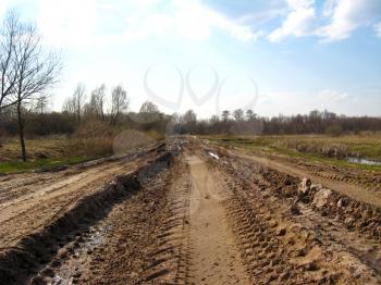 the image of rural road with greater traces of cars and a dirt