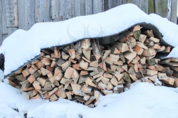 The image of heap of the prepared fire wood under snow