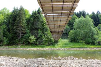 nice hanging bridge across speed, mountainous river