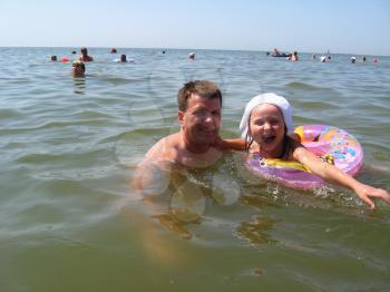 image of father and small daughter bathing in the sea