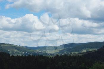 view to Carpathian mountains with forest and cloudly sky