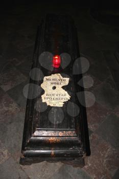candle on the coffin and inscription in Latin memento mori in church