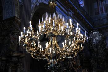 Beautiful chandelier with many candles under the church top