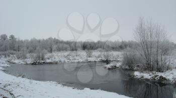 Winter landscape with unfrozen river and snow