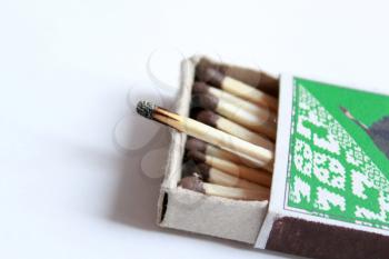 image of box full of matches and one burnt match