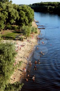 beautiful landscape with river and many people bathing near the beach