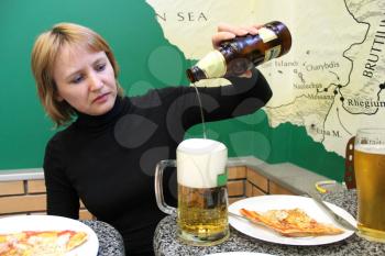 image of woman pouring beer in a glass and pizza