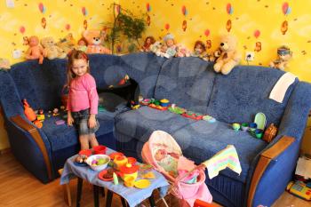little girl playing with toys and cat in her room