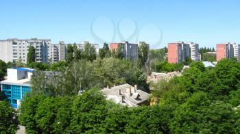 Panorama from a window on city with multystorey houses and many green trees