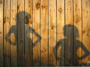 Shadow of boy and girl staring each other on wooden surface