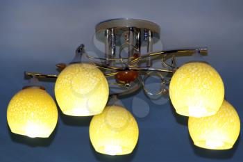 Beautiful chandelier with five bright plafonds under the ceiling
