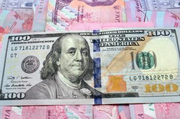 hundred dollars paper on the Ukrainian grivnas banknotes background
