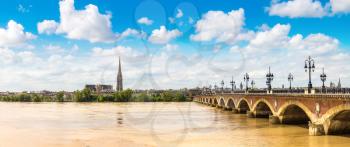 Panorama of Pont de pierre, old stony bridge in Bordeaux in a beautiful summer day, France