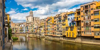 Colorful houses, Eiffel bridge and Saint Mary Cathedral at background in Girona, in a beautiful summer day, Catalonia, Spain
