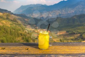 Glass of pineapple juice in front of Terraced rice field in Sapa, Vietnam in a summer day