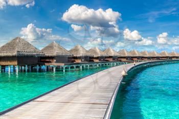 MALDIVES - JUNE 24, 2018: Water Villas (Bungalows) and wooden bridge at Tropical beach in the Maldives at summer day