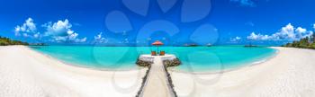 Panorama of Wooden sunbed and umbrella on tropical beach in the Maldives at summer day