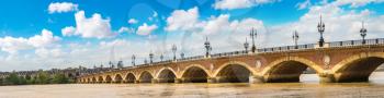 Panorama of Pont de pierre, old stony bridge in Bordeaux in a beautiful summer day, France