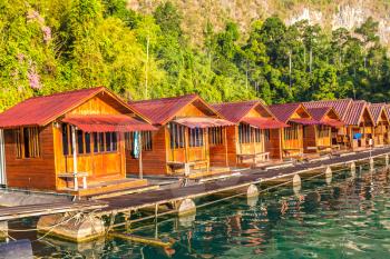 Traditional Thai bungalows at Cheow Lan lake, Ratchaprapha Dam, Khao Sok National Park in Thailand in a summer day