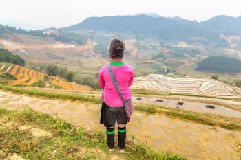 Woman wearing traditional clothes at Terraced rice field in Sapa, Lao Cai, Vietnam in a summer day
