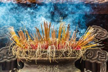 Burning incense sticks in Tran Quoc pagoda in Hanoi, Vietnam in a summer day