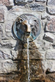  Street faucet with a lion head with a stream of fresh water coming out of it's mouth. Lion water fountain sculpture in Khakiv. Ukraine.