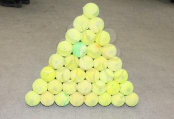 Tennis balls collected in the form a pyramid. Set of tennis balls.