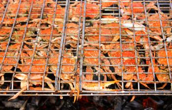 Grilled crab on flaming grill. Charcoal fire grill. Barbecue embers glowing in red fire.