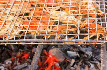 Grilled crab on flaming grill. Charcoal fire grill. Barbecue embers glowing in red fire.