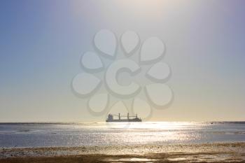 Sea ship sails along the shore at sun light