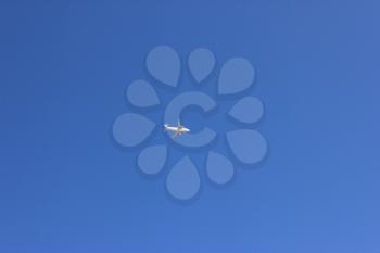 White airplane flying on blue sky background