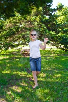 Photo of cute dancing girl with sunglass in summer