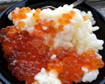 Rice with red caviar in black chalice