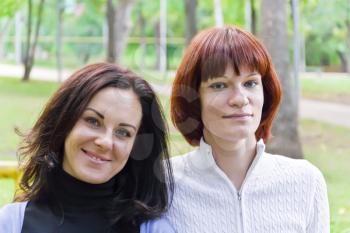 Photo of two women with brown and black hairs
