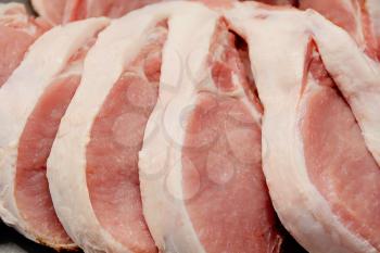 Image of many raw pork chops on counter