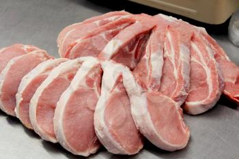 Image of many raw pork chops on counter