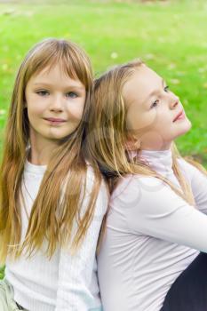 Photo of two sitting girls in summer