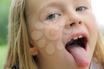 Portrait of girl with put out tongue