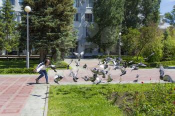 Photo of European woman playing with pigeons