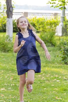 Cute running European girl in green summer