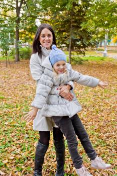 Photo of playing mother and daughter in autumn