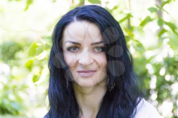 European woman with black hair on green background